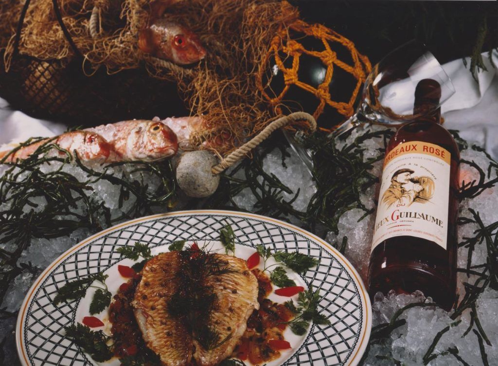 Assiette de cuisine accompagnée d’une bouteille de Vieux Guillaume